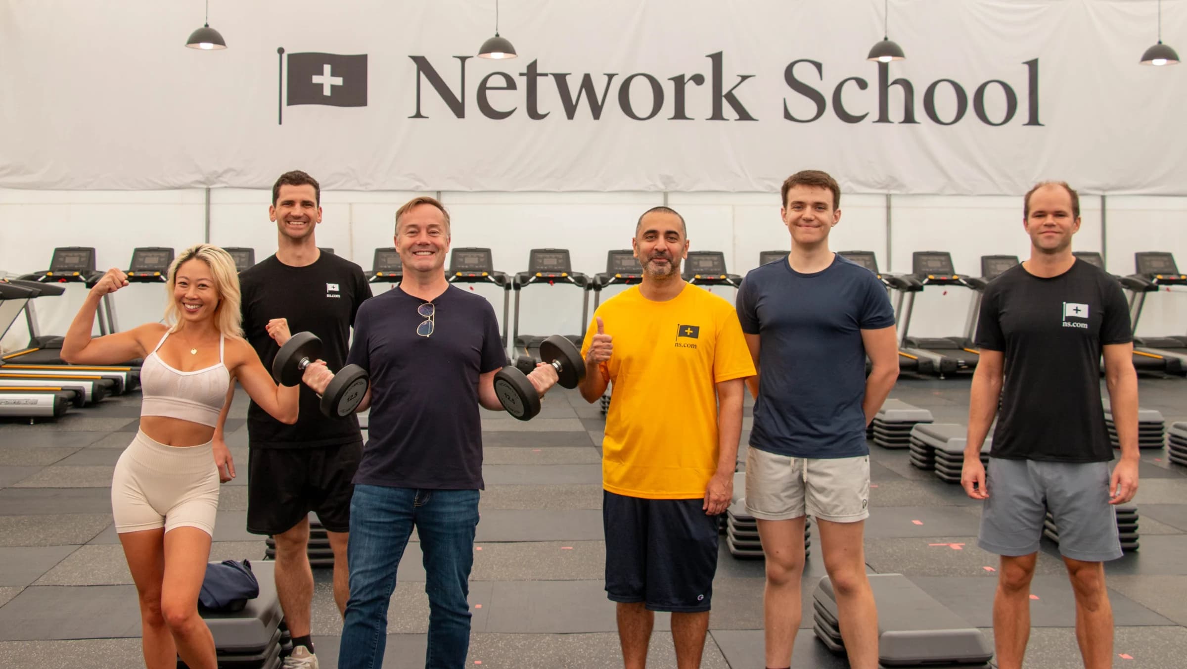 Network School, Singapore. Group photo in the gym under the Network School banner.